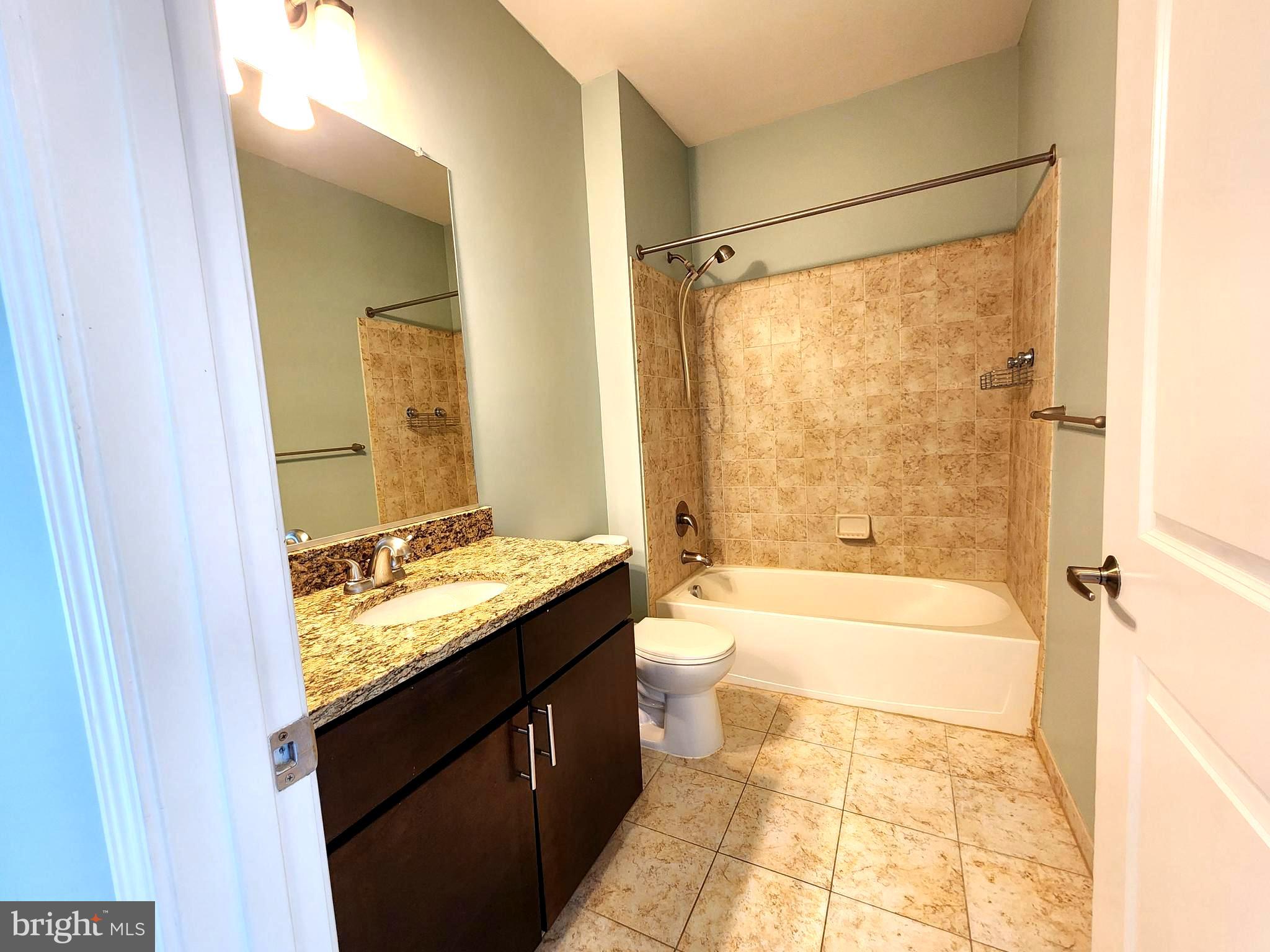 2610 Sheridan Road Southeast, Unit 3 Washington, DC 20020 - Photo 23 of 30 a bathroom with a granite countertop sink a toilet and shower