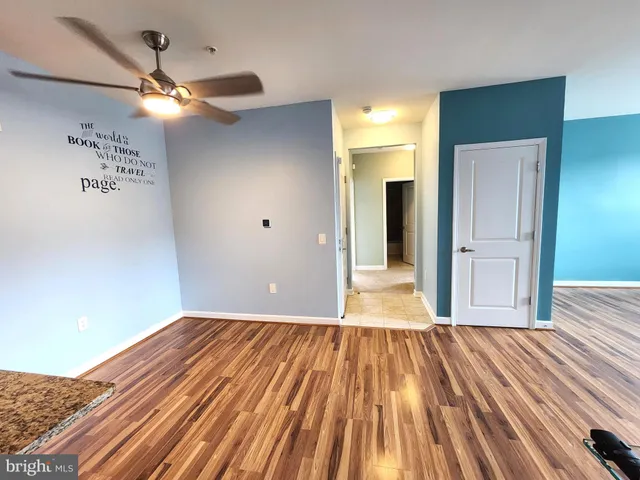 a view of a room with wooden floor fan and windows
