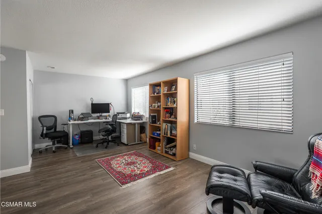 a view of a workspace with furniture and a window