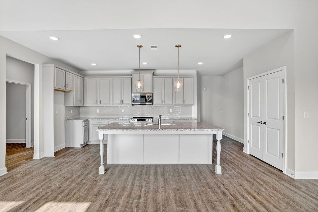 146 Wild Turkey Pass Homer, GA 30547 - Photo 14 of 38 a kitchen with stainless steel appliances a sink stove and wooden floor