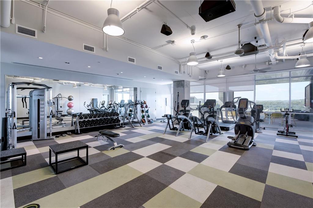 222 West Avenue, Unit 2207 Austin, TX 78701 - Photo 17 of 30 Fitness center featuring a checkerboard pattern flooring, exposed ceiling ducts, pendant lighting, and floor-to-ceiling windows