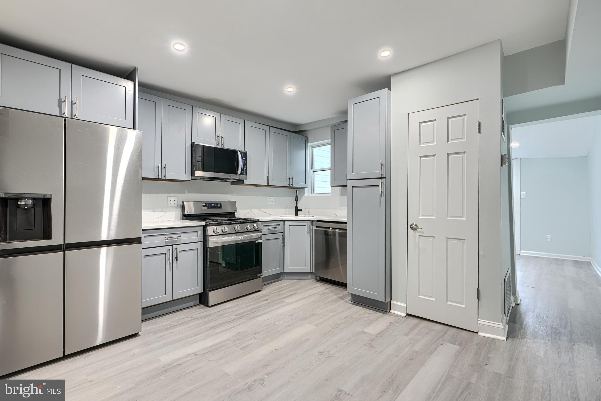 3606 Old York Road Baltimore, MD 21218 - Photo 10 of 35 a kitchen with a refrigerator a stove top oven and wooden floor