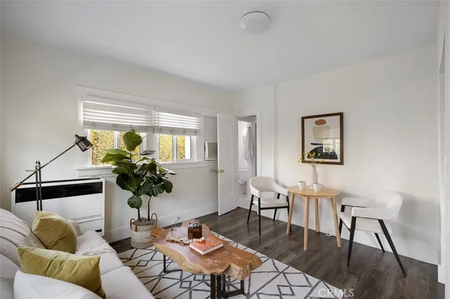 a bedroom with a bed a large window with table and chairs
