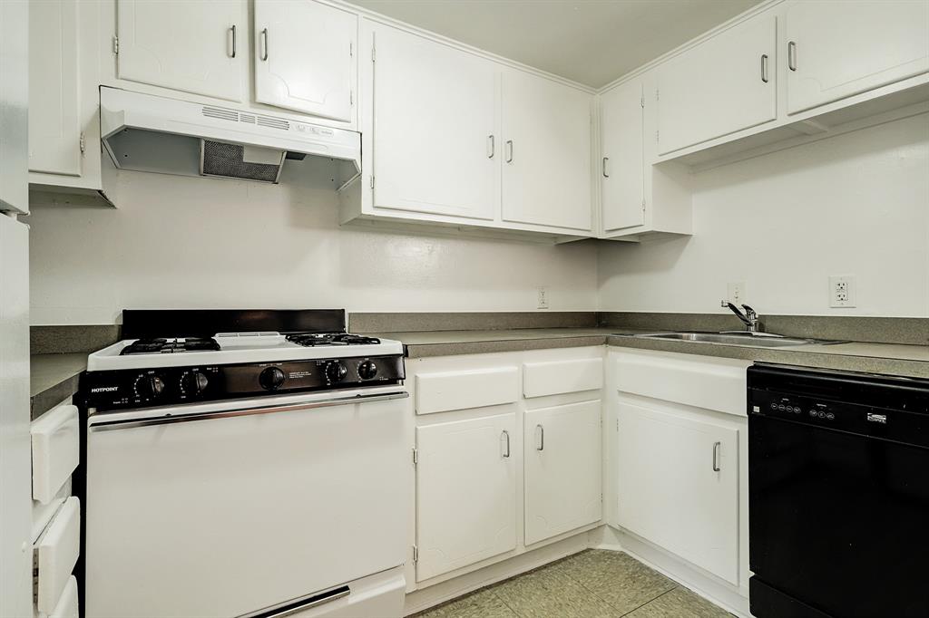 a white kitchen with granite countertop stainless steel appliances