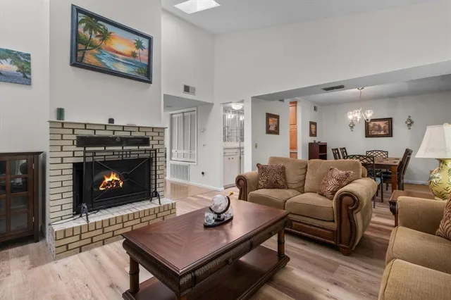a view of a hallway with wooden floor and a bathroom