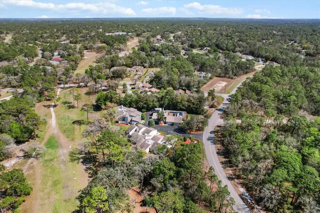 a view of a house with backyard and bushes