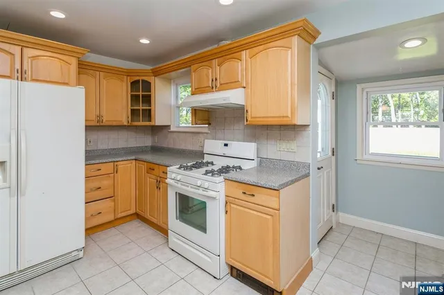 a kitchen with stainless steel appliances granite countertop a stove a refrigerator and a refrigerator