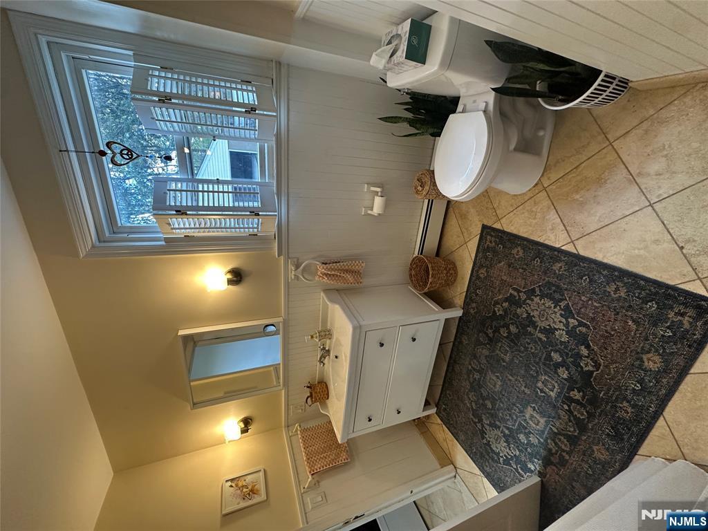 332 Closter Dock Road, Unit 1 Closter, NJ 07624 - Photo 9 of 21 a bathroom with a toilet sink and mirror