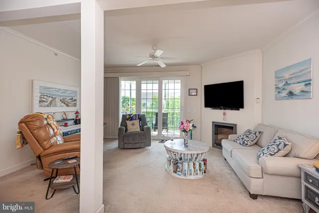 a living room with furniture a flat screen tv and a floor to ceiling window