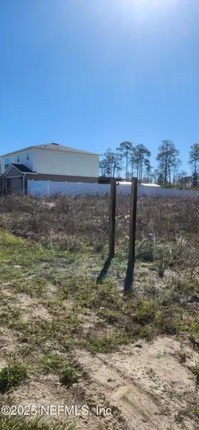a view of a dry yard with wooden fence