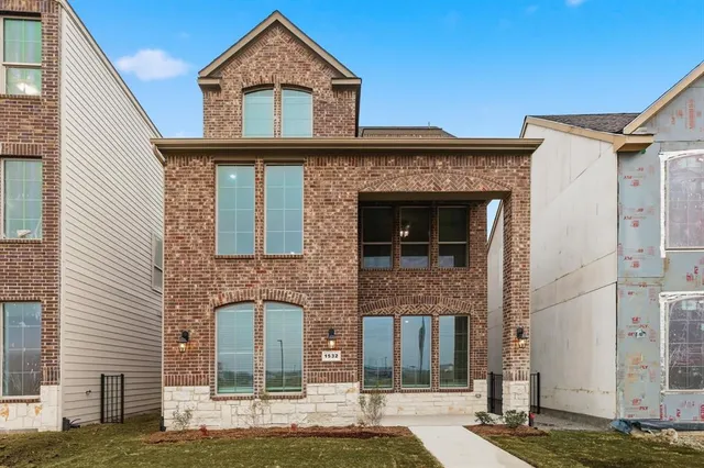 a view of a brick house with large windows