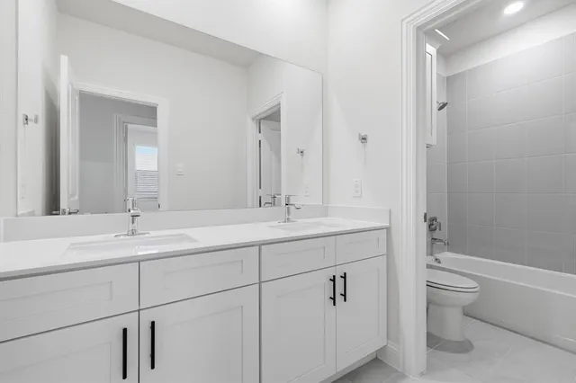 a bathroom with a granite countertop sink a toilet and a tub