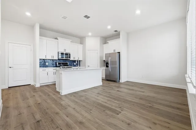 a kitchen with stainless steel appliances a refrigerator sink and microwave
