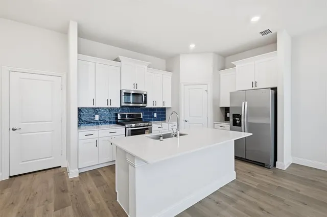 a kitchen with stainless steel appliances a refrigerator sink and microwave