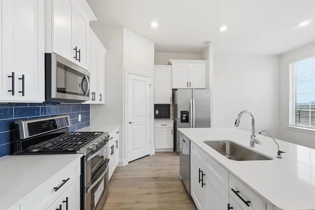 a kitchen with a sink stove and refrigerator