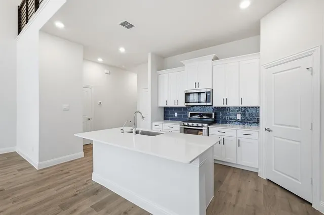 a kitchen with appliances a sink and cabinets