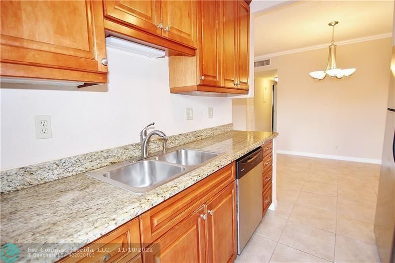 a kitchen with granite countertop a sink and a white stove