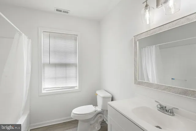 a bathroom with a sink toilet and mirror