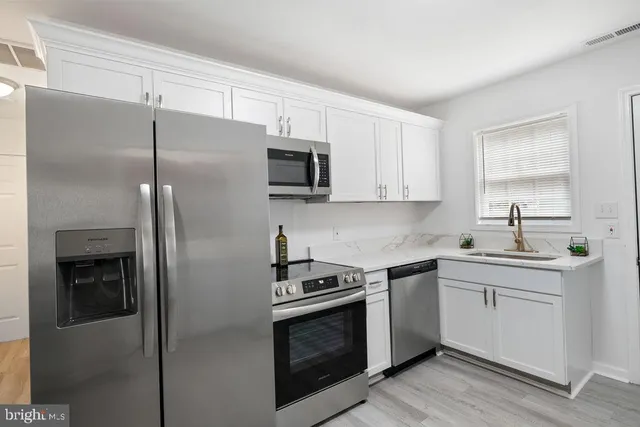 a kitchen with a sink and stainless steel appliances