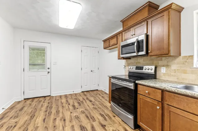 a kitchen with stainless steel appliances granite countertop a stove and a microwave