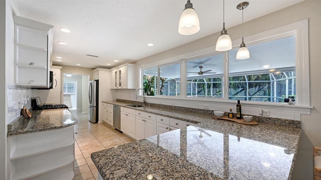 4810 Bay Shore Road Sarasota, FL 34234 - Photo 16 of 47 a kitchen with stainless steel appliances granite countertop a sink a stove and a wooden floors