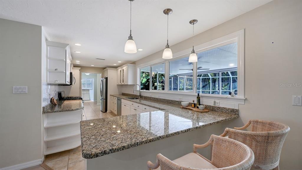 4810 Bay Shore Road Sarasota, FL 34234 - Photo 17 of 47 a kitchen with stainless steel appliances granite countertop a sink a stove and a wooden floor