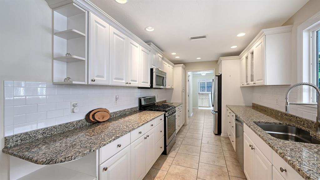 4810 Bay Shore Road Sarasota, FL 34234 - Photo 18 of 47 a kitchen with stainless steel appliances granite countertop a sink stove and refrigerator