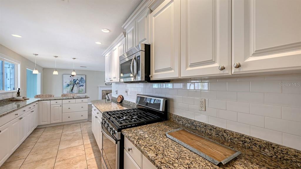 4810 Bay Shore Road Sarasota, FL 34234 - Photo 20 of 47 a kitchen with granite countertop a stove sink and cabinets