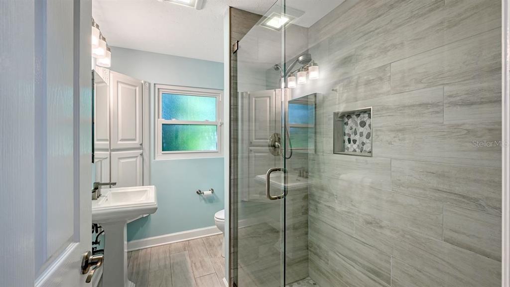 4810 Bay Shore Road Sarasota, FL 34234 - Photo 32 of 47 a bathroom with a light fixture a sink and a mirror