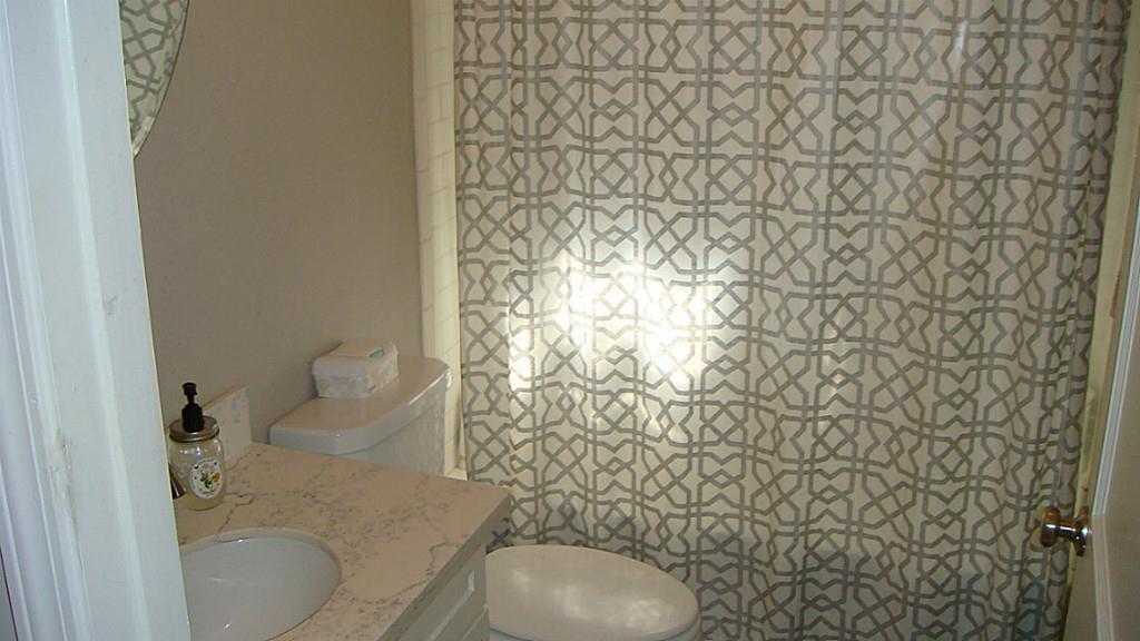 112 Robert Lee Road Houston, TX 77009 - Photo 6 of 14 a bathroom with a toilet and a shower curtain