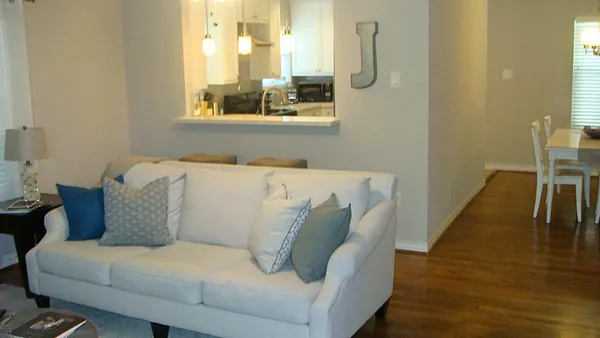 a large white couch sitting in a bedroom next to a window