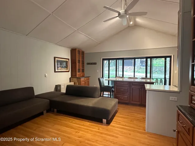 a living room with furniture a large window and a dining table