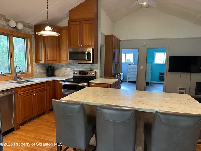 a kitchen with a sink a counter top space appliances and cabinets