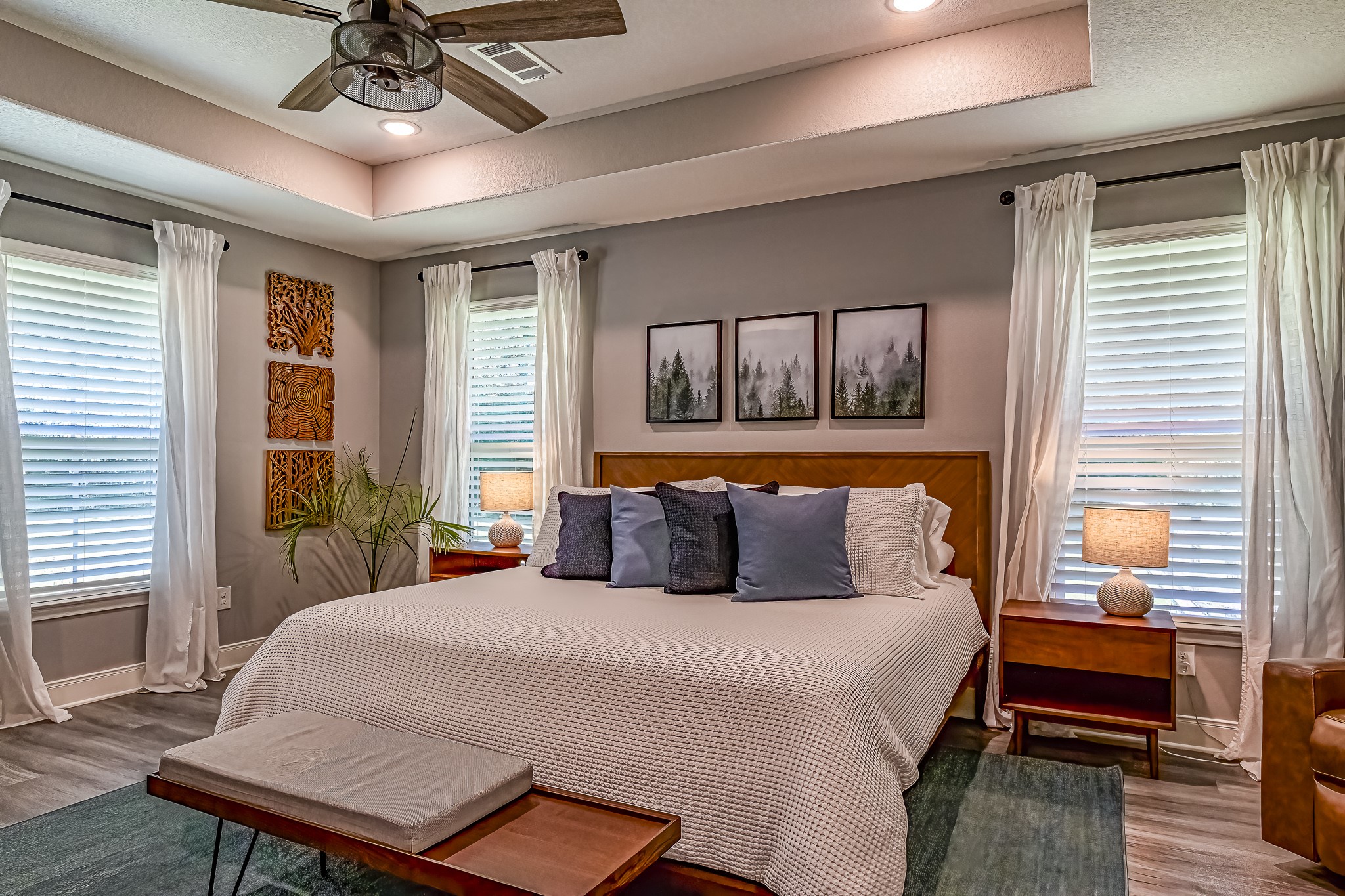 40 Bob Steele Road Coldspring, TX 77331 - Photo 19 of 50 a bedroom with a large bed a chandelier and windows