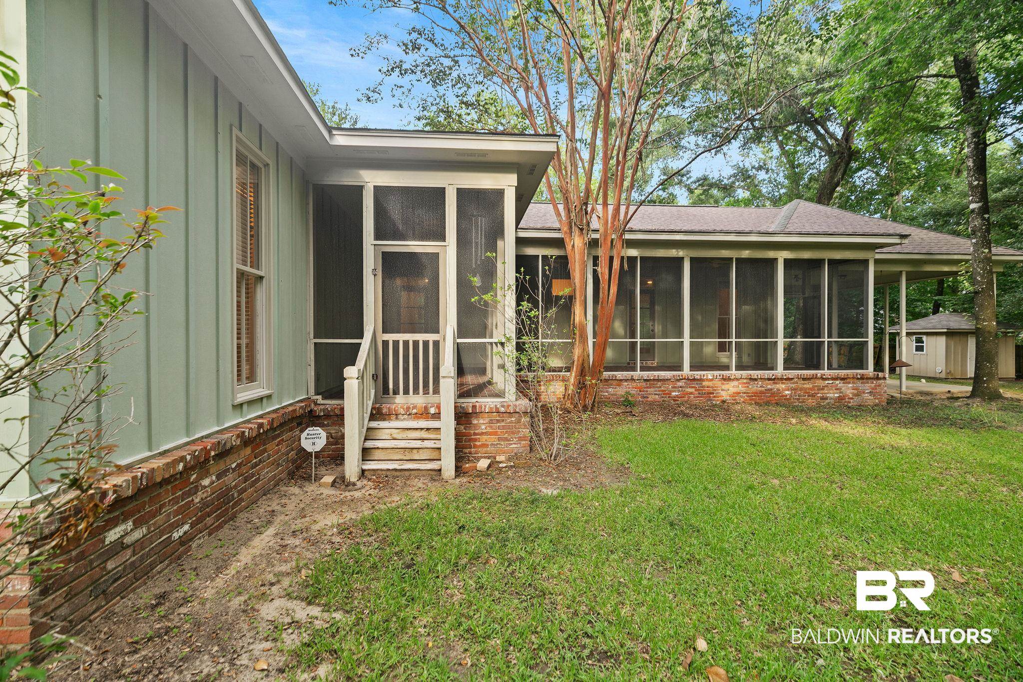 202 Beall Lane Daphne, AL 36526 - Photo 37 of 46 Exterior space with a sunroom and a lawn
