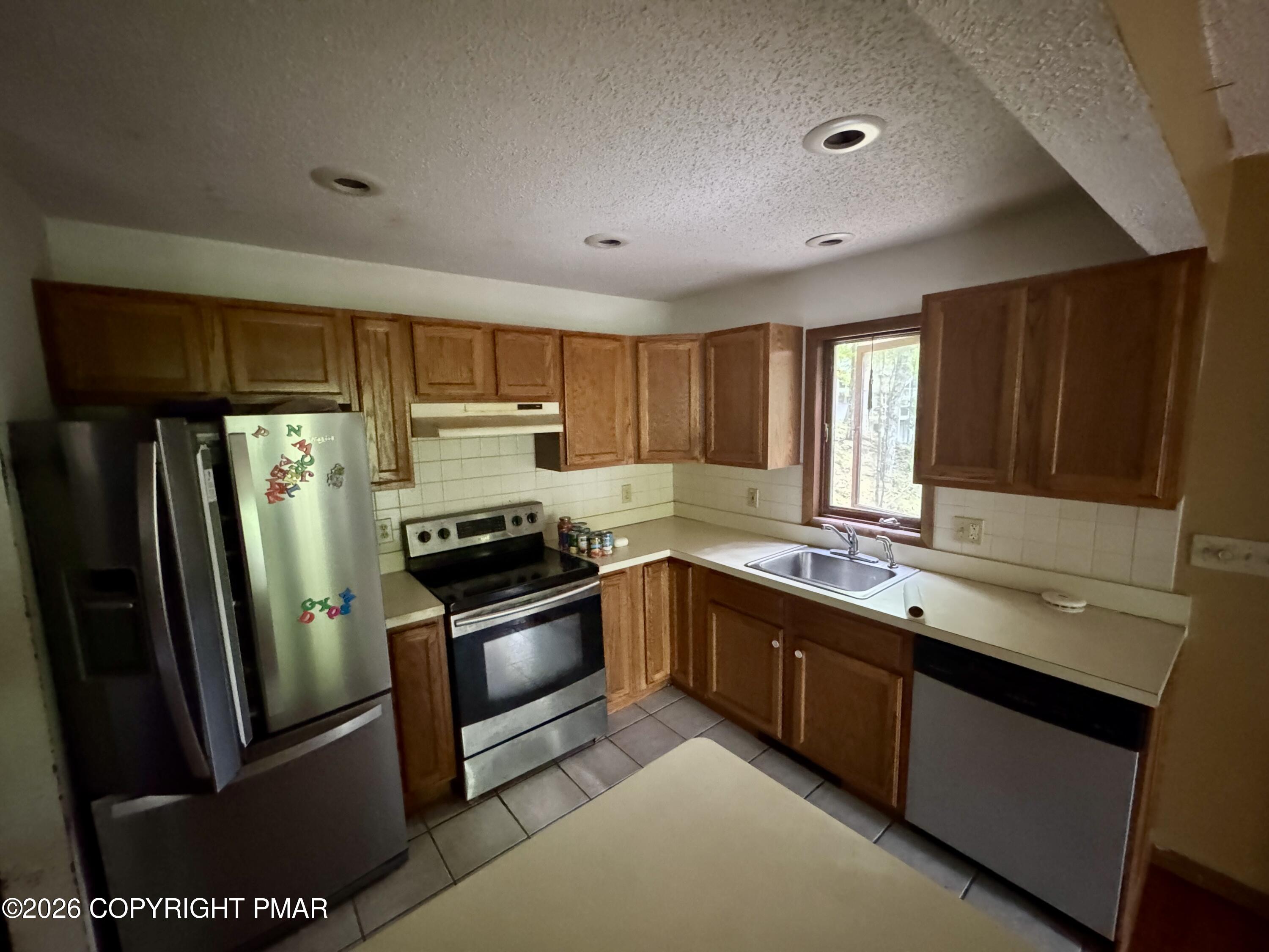119 Durham Drive Bushkill, PA 18324 - Photo 4 of 41 a kitchen with stainless steel appliances granite countertop a refrigerator a sink a stove a washer dryer and cabinets