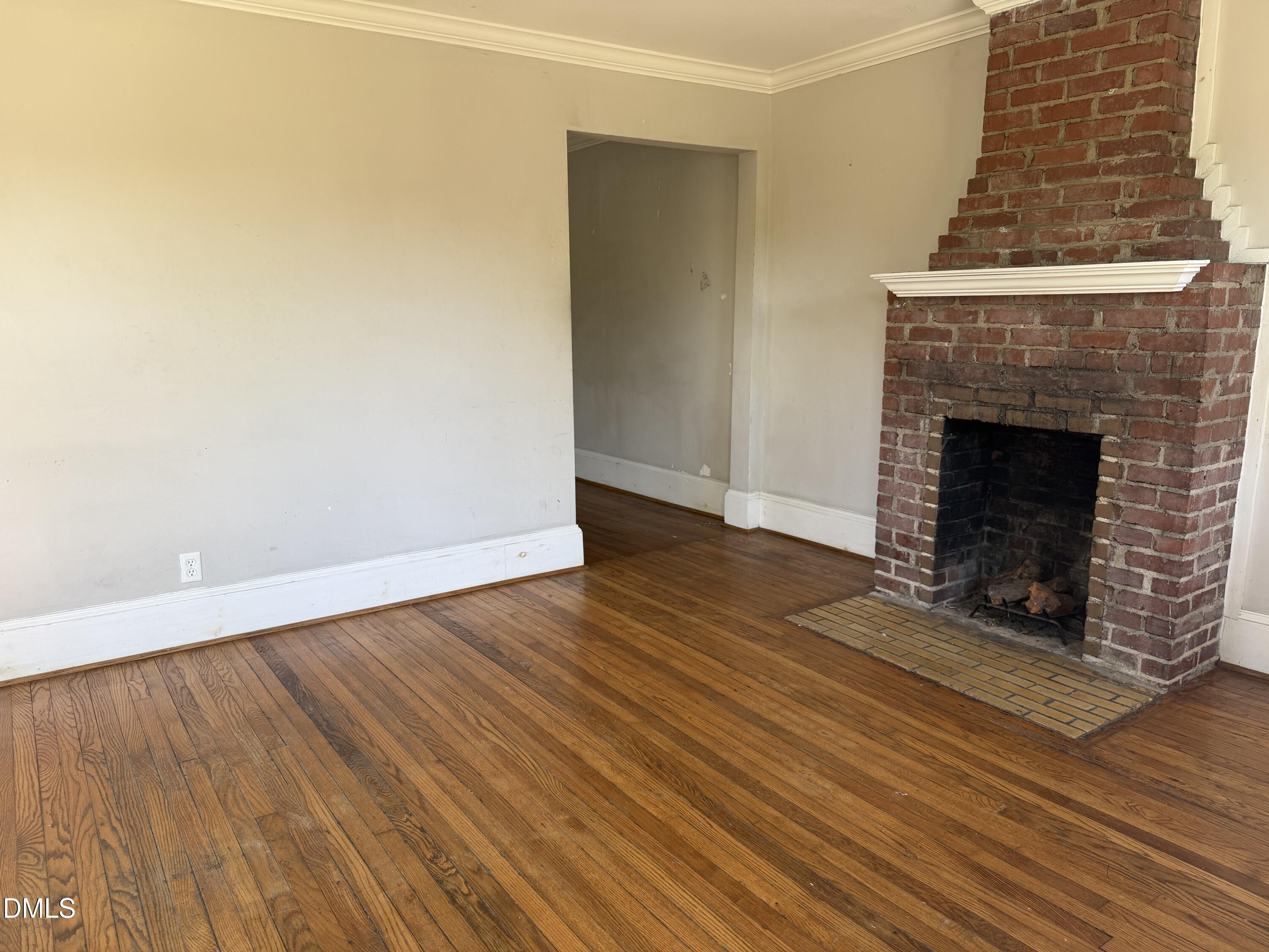 210 West Geer Street Durham, NC 27701 - Photo 5 of 15 an empty room with wooden floor and fireplace