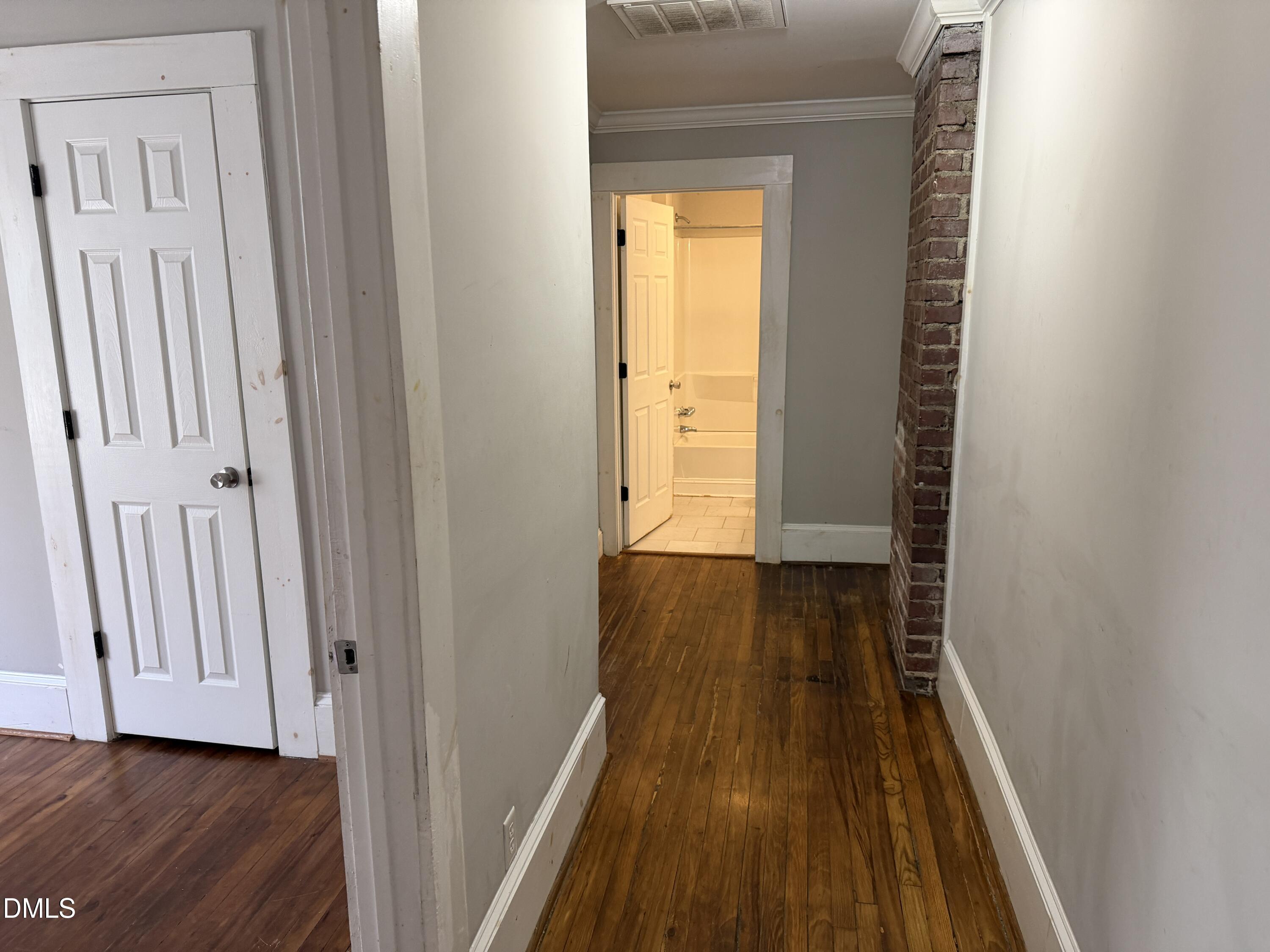 210 West Geer Street Durham, NC 27701 - Photo 8 of 15 a view of a hallway with wooden floor and a bathroom