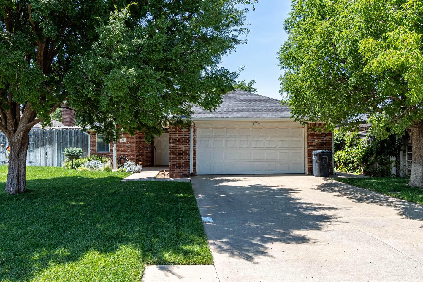 6364 Suncrest Way Amarillo, TX 79124 - Photo 1 of 18 a front view of a house with a garden and trees