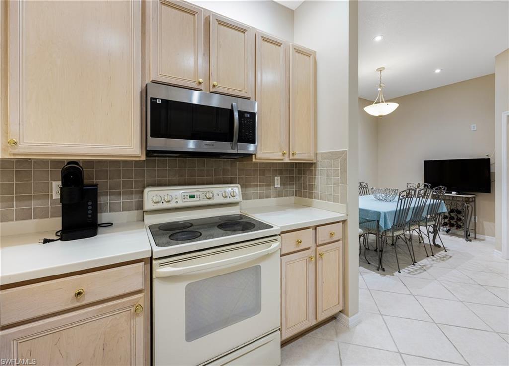 3641 Periwinkle Way Naples, FL 34114 - Photo 11 of 45 a kitchen with white cabinets and appliances