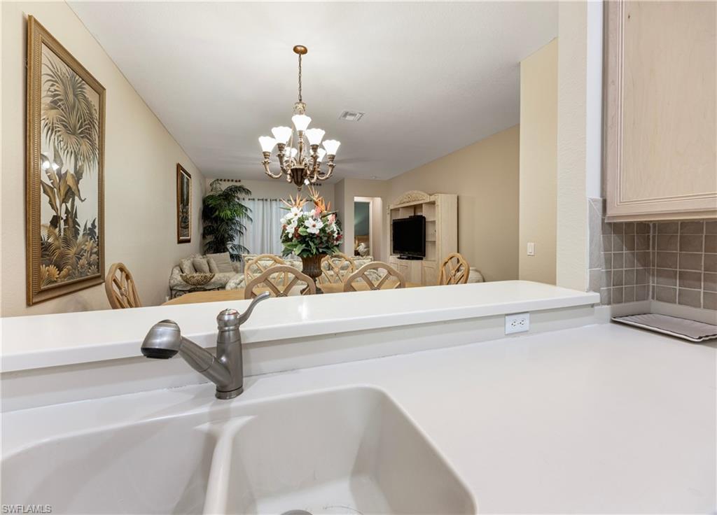 3641 Periwinkle Way Naples, FL 34114 - Photo 14 of 45 a view of living room with granite countertop furniture and a chandelier