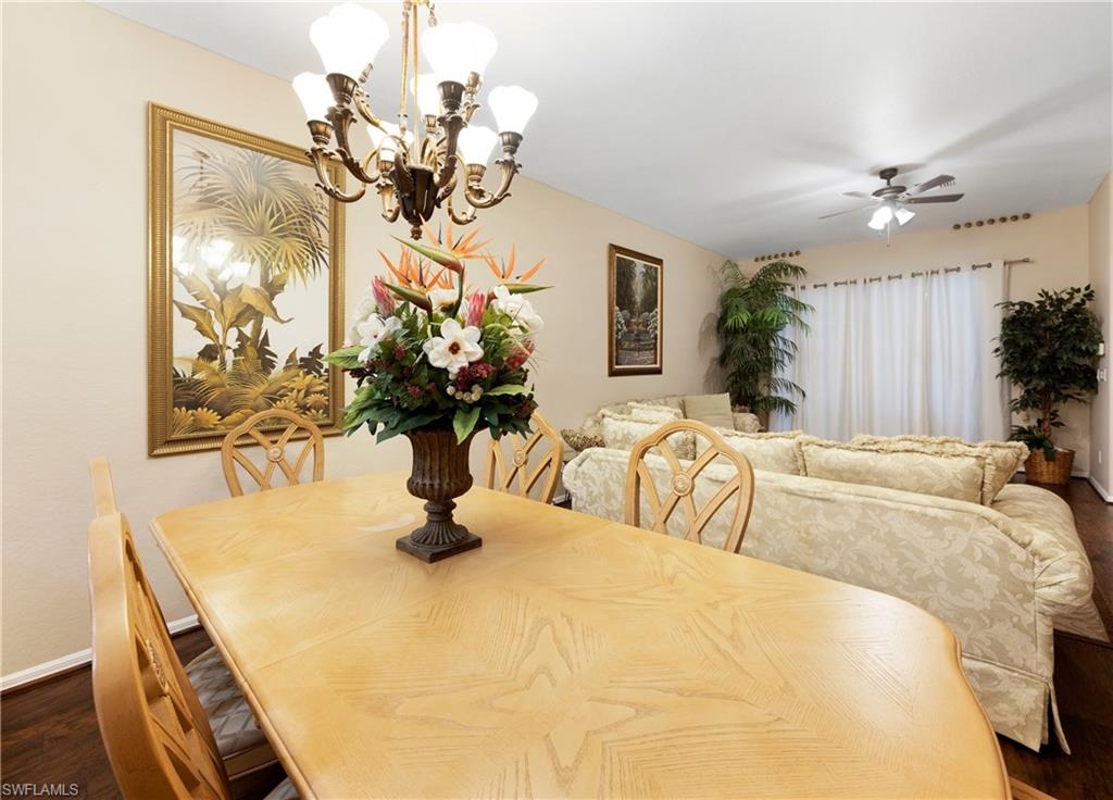 3641 Periwinkle Way Naples, FL 34114 - Photo 18 of 45 a bedroom with a bed a chandelier and flat screen