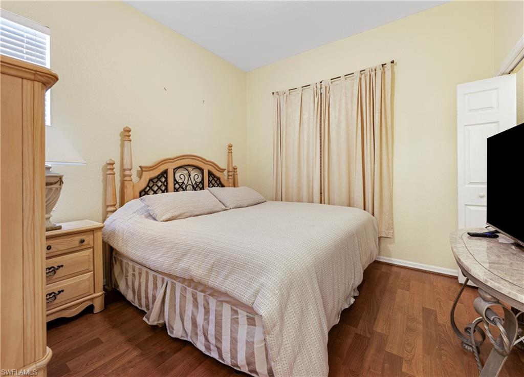 3641 Periwinkle Way Naples, FL 34114 - Photo 22 of 45 a bedroom with a bed and a flat tv screen on a dresser