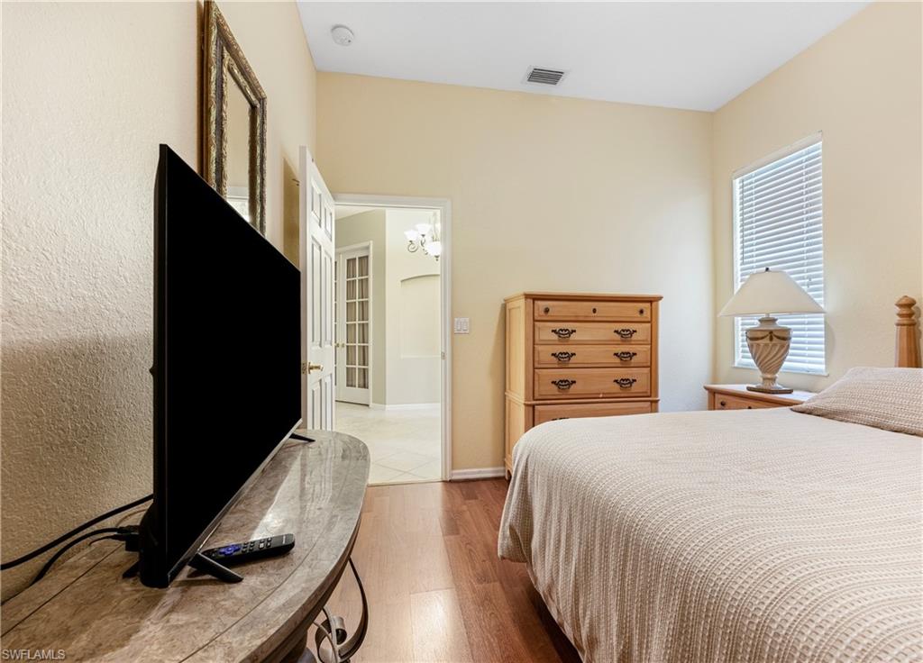3641 Periwinkle Way Naples, FL 34114 - Photo 23 of 45 a bedroom with a bed and a flat tv screen on dresser