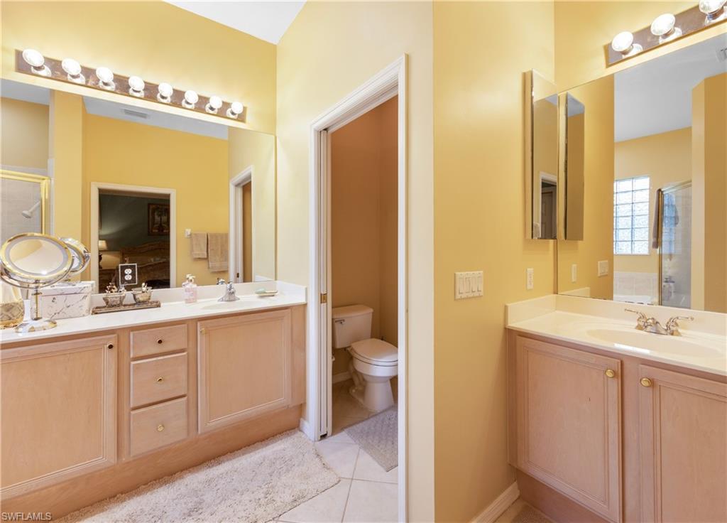 3641 Periwinkle Way Naples, FL 34114 - Photo 29 of 45 a bathroom with a granite countertop sink a toilet and a mirror