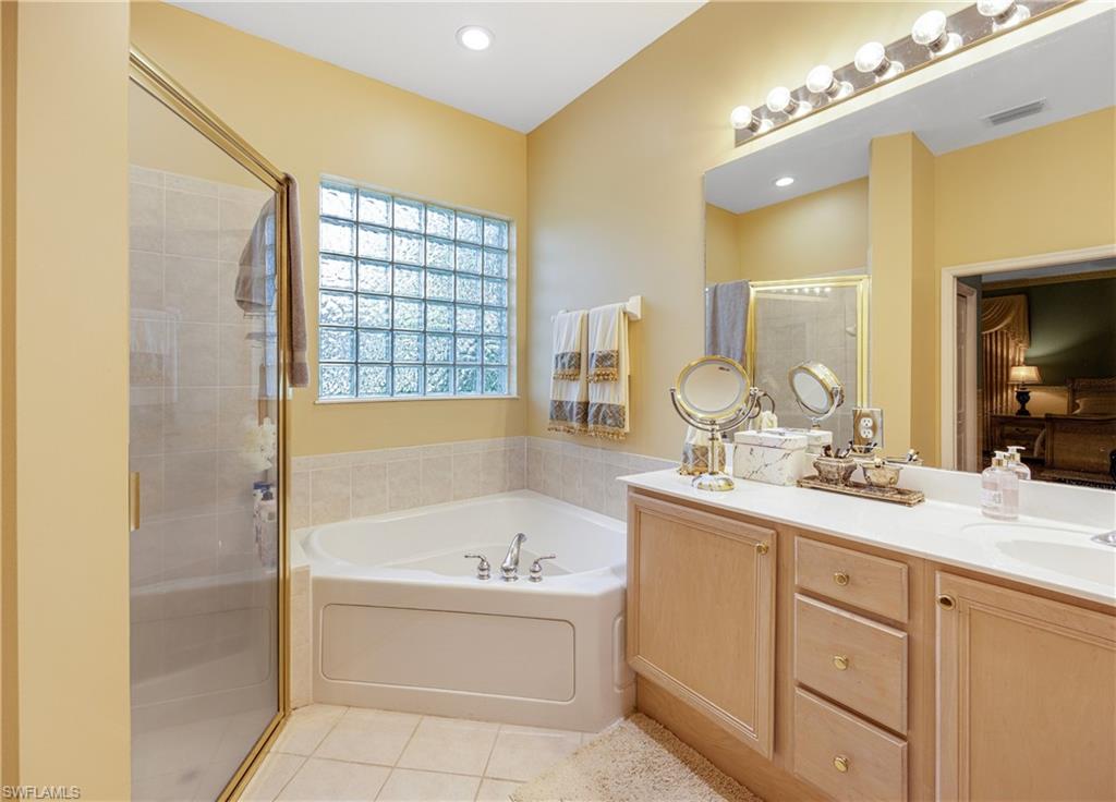 3641 Periwinkle Way Naples, FL 34114 - Photo 30 of 45 a bathroom with a tub sink and mirror