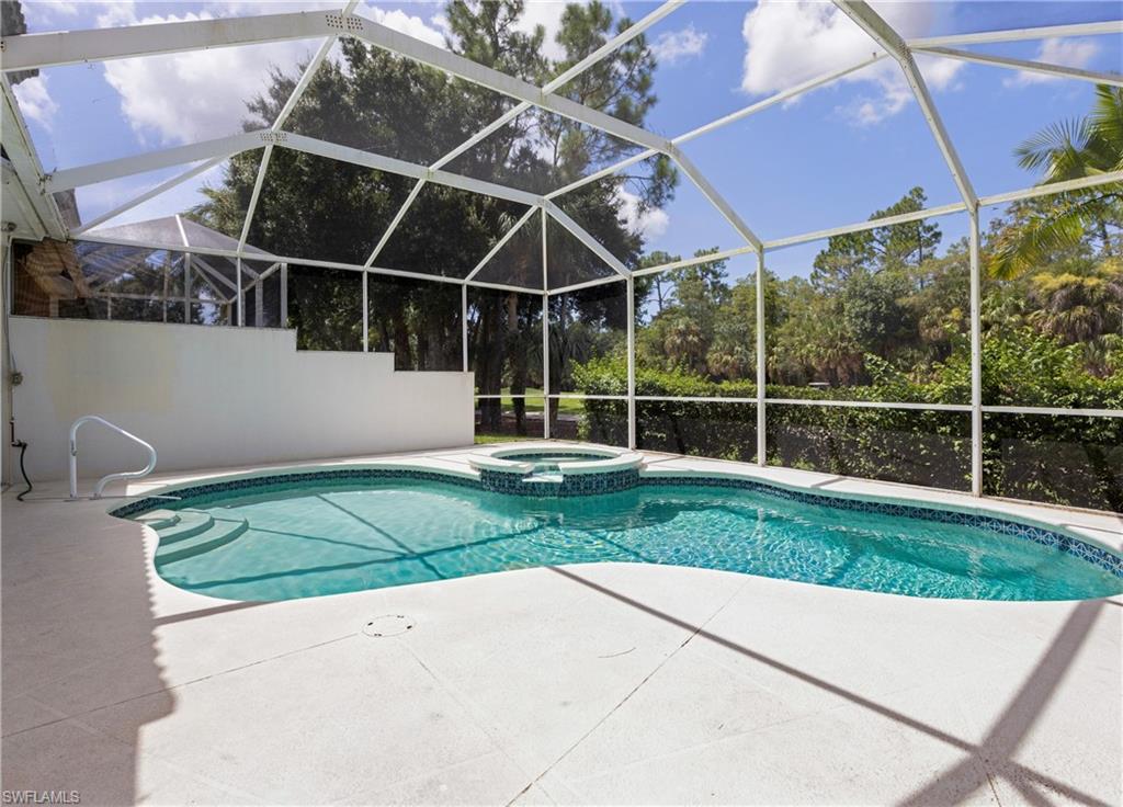 3641 Periwinkle Way Naples, FL 34114 - Photo 33 of 45 a view of a backyard with table and chairs under an umbrella