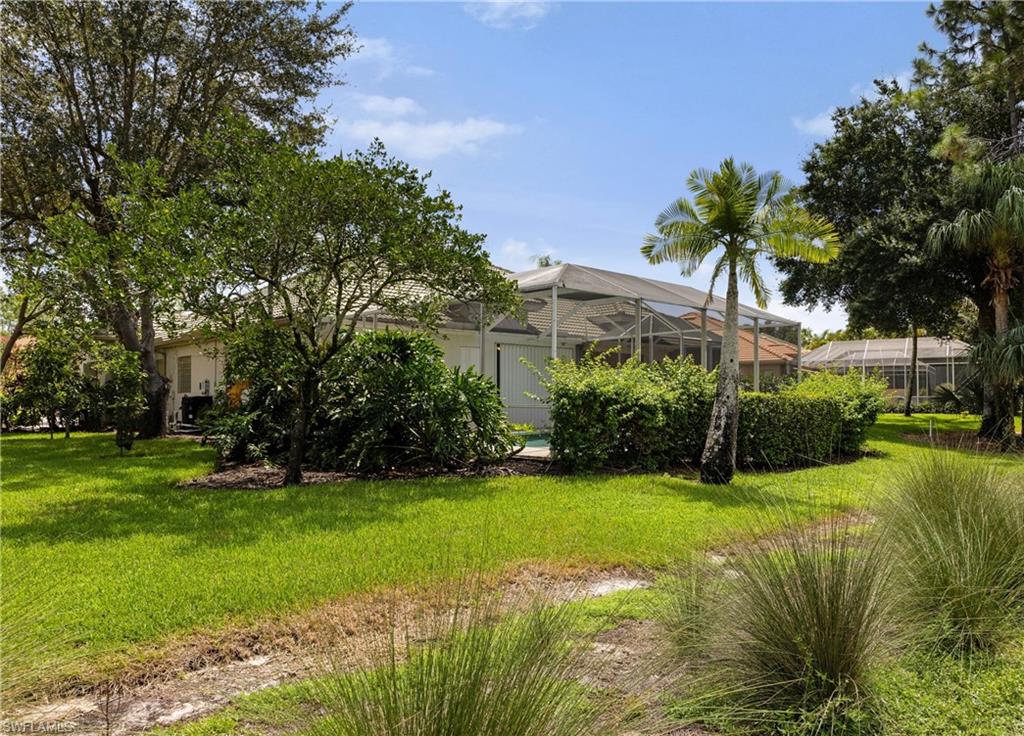 3641 Periwinkle Way Naples, FL 34114 - Photo 36 of 45 a view of a house with a big yard and palm trees