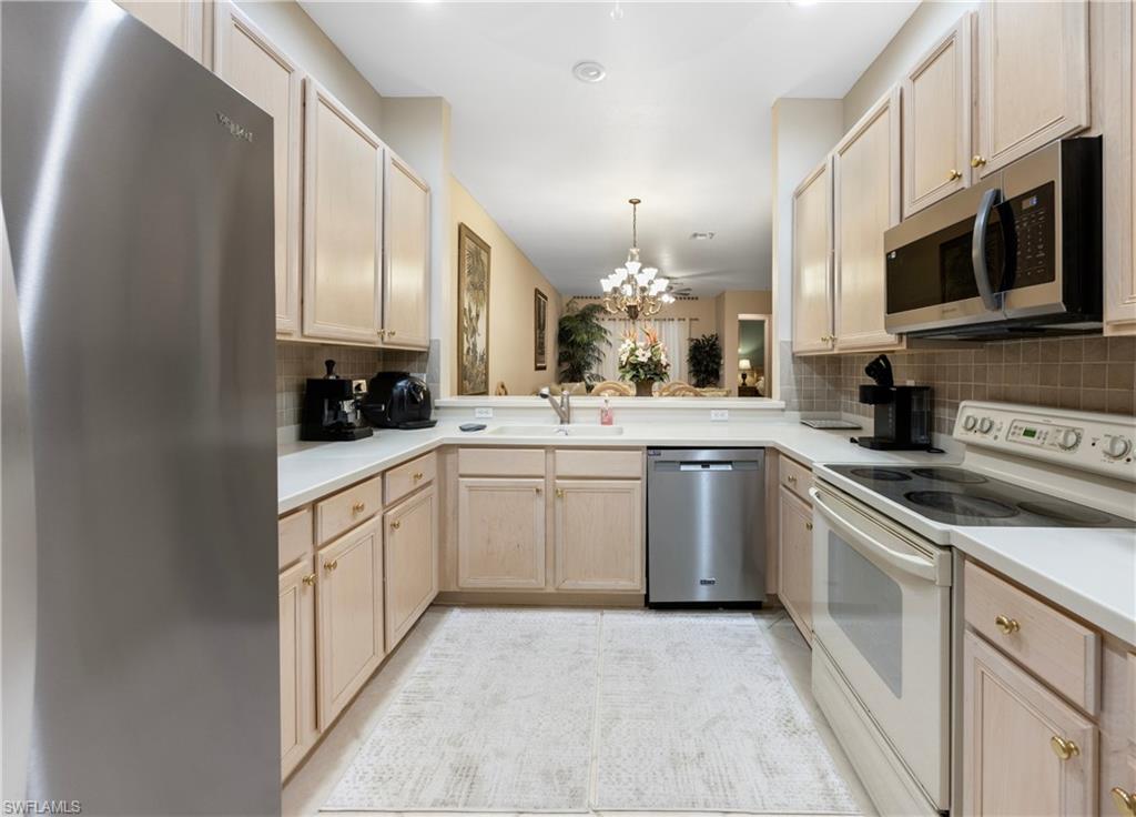 3641 Periwinkle Way Naples, FL 34114 - Photo 10 of 45 a kitchen with stainless steel appliances granite countertop a sink and a stove