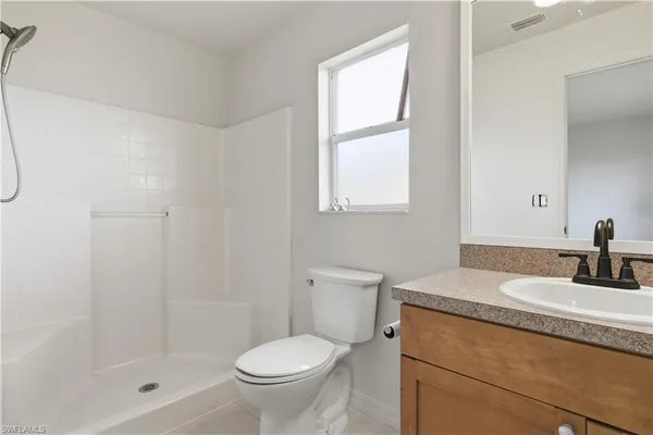 a bathroom with a granite countertop sink toilet and shower